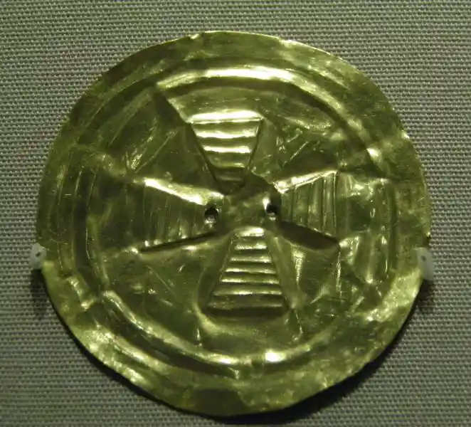 Circular gold disc with a cross in the middle